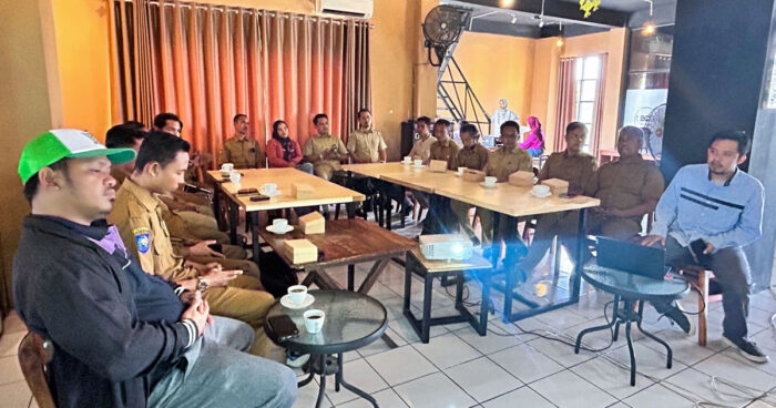 Sejumlah peserta, sebagian besar mengenakan seragam dinas cokelat, mengikuti kegiatan penguatan kapasitas pemerintah desa tentang mitigasi dan adaptasi perubahan iklim di ruang pertemuan yang dilengkapi laptop dan proyektor.